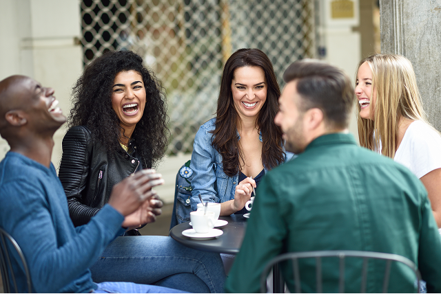 A group of 5 adults drinking coffee and laughing